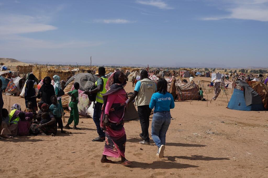 联合国儿童基金会的一名员工穿过苏丹难民营.